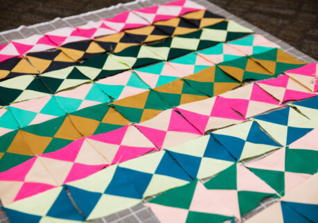 Bright colored hour-glass quilt blocks in pinks, greens, blues